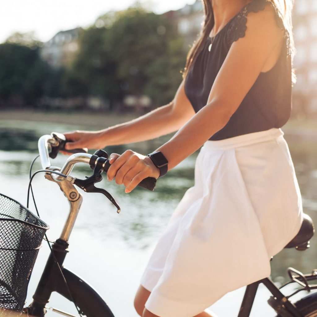 Menina numa bicicleta com um relógio inteligente